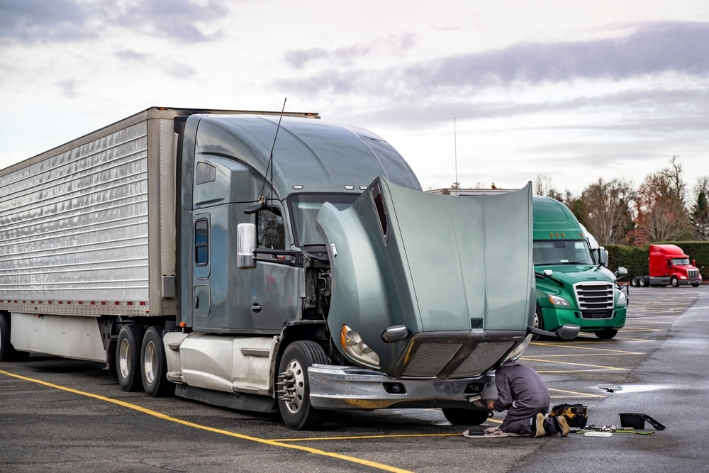 TruckDriverRepairingBrokenGrayBigRigSemiTruckWith