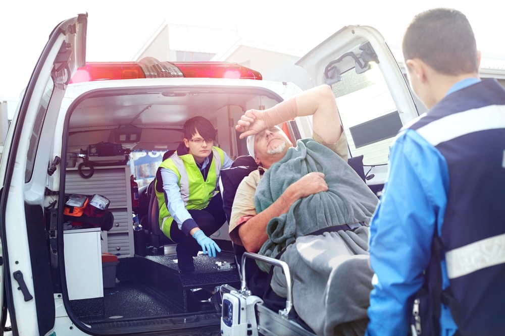 RescueWorkersLoadingCarAccidentVictimIntoBackOfAmbulance