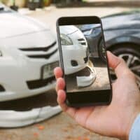 AManHoldsASmartphoneToTakePicturesOfThe