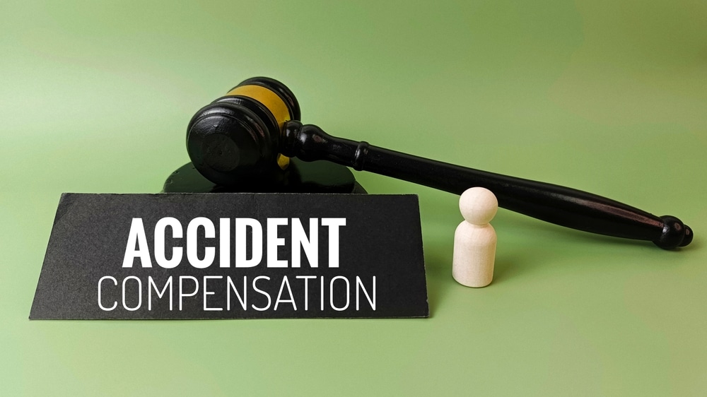 AccidentCompensationConceptWithJudgeGavelAndTwoDamagedCars