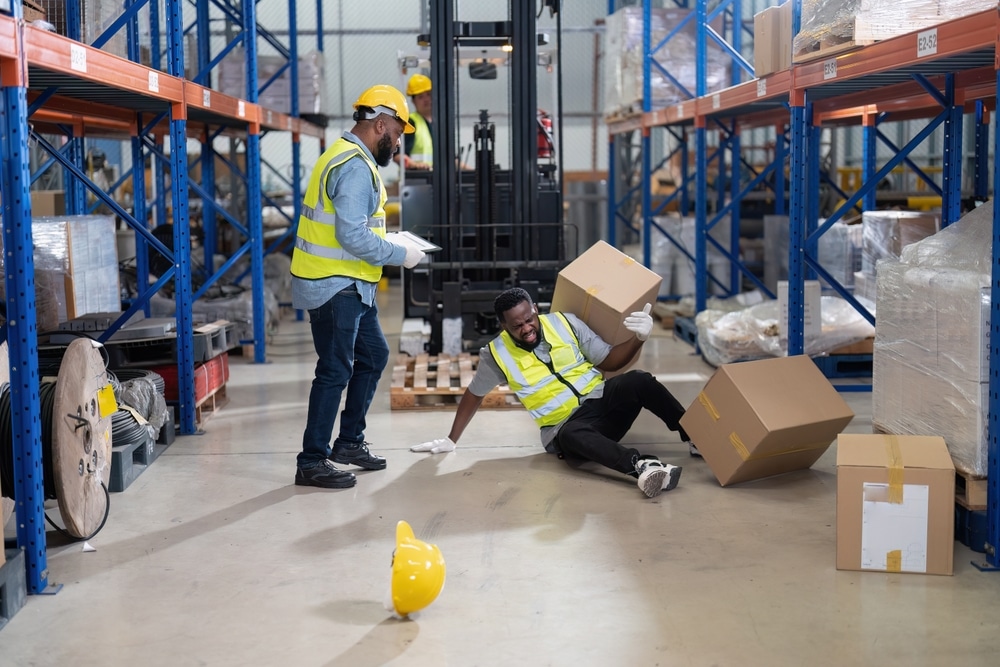 AfricanAmericanWorkingInWarehouseGotAccidentFromCarryBox