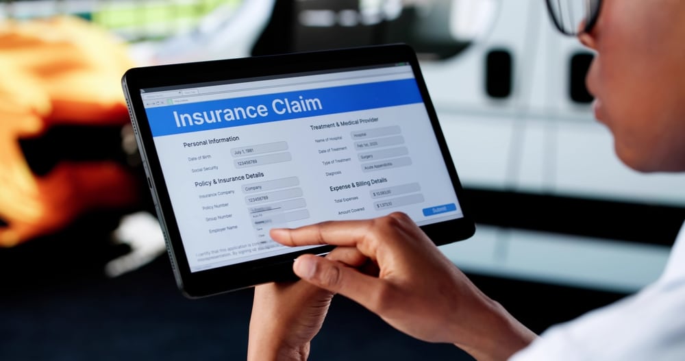 BlackWomanInspectingCarDamageForInsuranceClaimOnTablet
