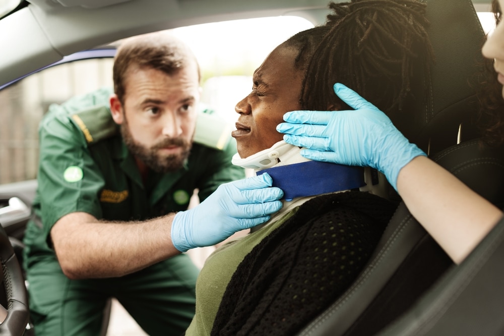 ParamedicAssistsInjuredPersonInCarEmergencyCareNeckBrace