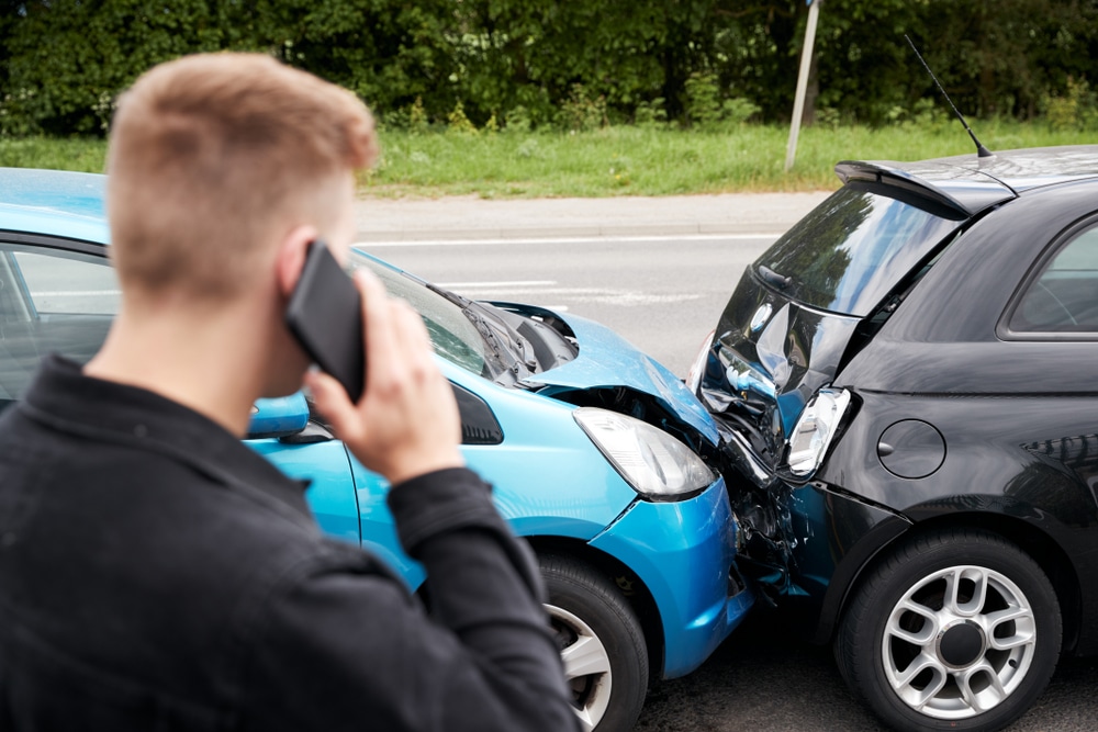 YoungMaleMotoristInvolvedInCarAccidentCallingInsuranceCompany